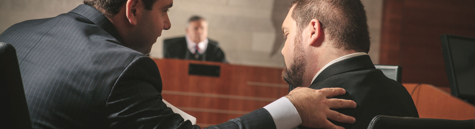 Attorney Fienman speaking with client in courtroom